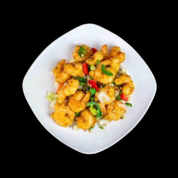 Golden fried shrimp with red and green peppers, onions, and scallions on a white plate.